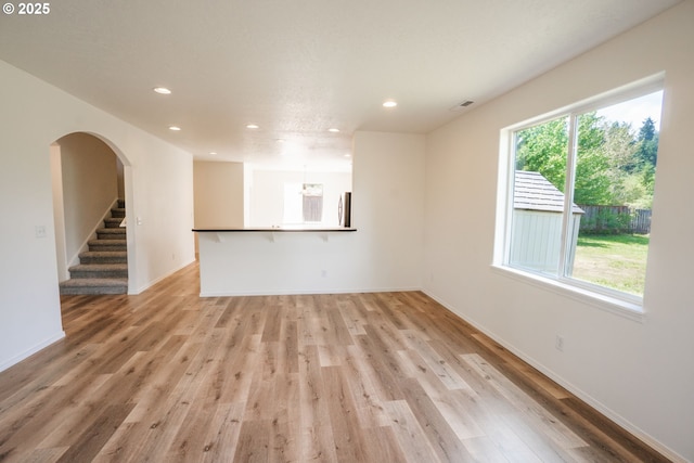 24823 Hawks View Dr, Veneta, OR 97487 - unfurnished living room with recessed lighting, light wood-style floors, arched walkways, and stairway