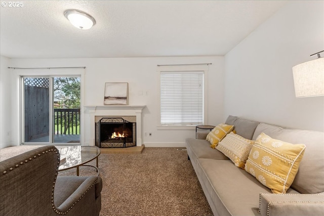 carpeted living room with a high end fireplace, a textured ceiling, and baseboards