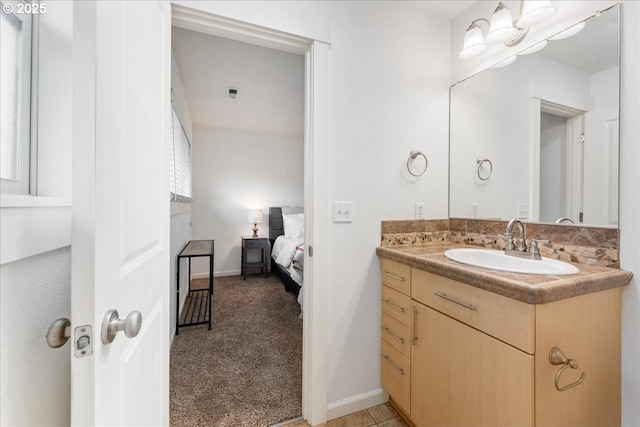 bathroom featuring visible vents, connected bathroom, vanity, and baseboards