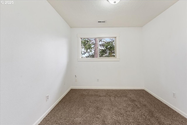 unfurnished room featuring visible vents, baseboards, a textured ceiling, and carpet flooring