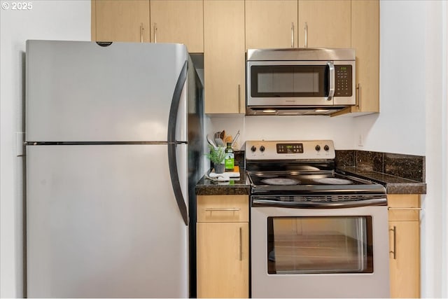 kitchen featuring light brown cabinetry, appliances with stainless steel finishes, and dark countertops