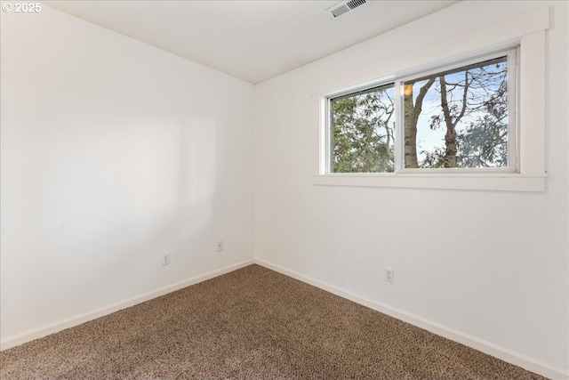 spare room with visible vents, carpet flooring, and baseboards