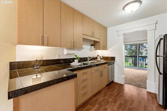 kitchen with freestanding refrigerator, a sink, dark wood-type flooring, a textured ceiling, and dishwasher