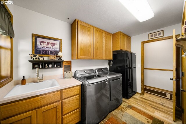 33817 Gage Rd, Mitchell, OR 97750 - laundry area featuring washing machine and clothes dryer, cabinet space, and light wood-style flooring