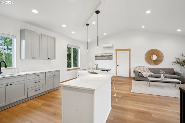 16000 NE Grantham Rd, Amboy, WA 98601 - kitchen with a sink, gray cabinets, an AC wall unit, a center island, and vaulted ceiling