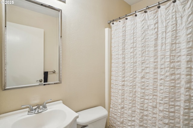 full bath featuring a sink, toilet, and a shower with shower curtain