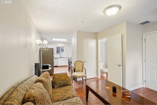 living room with wood finished floors, a textured ceiling, and radiator