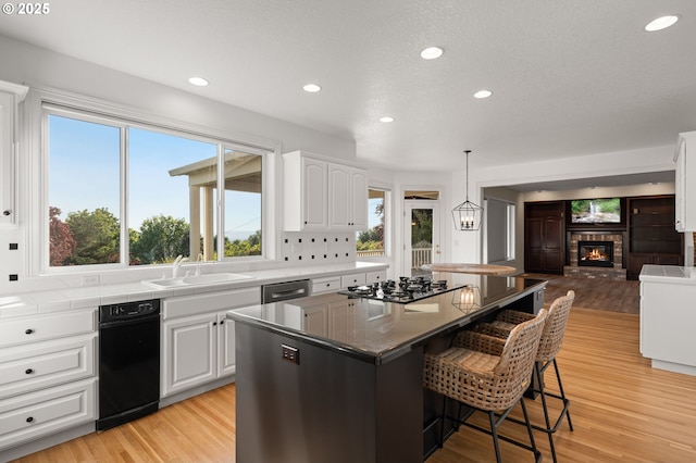 14405 NW Valley View Ln, Portland, OR 97231 - kitchen with a sink, a breakfast bar area, white cabinetry, recessed lighting, and open floor plan