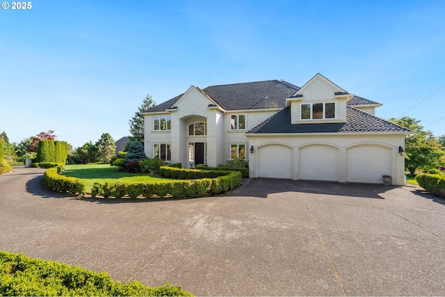 14405 NW Valley View Ln, Portland, OR 97231 - french provincial home featuring stucco siding, asphalt driveway, an attached garage, a front yard, and roof with shingles