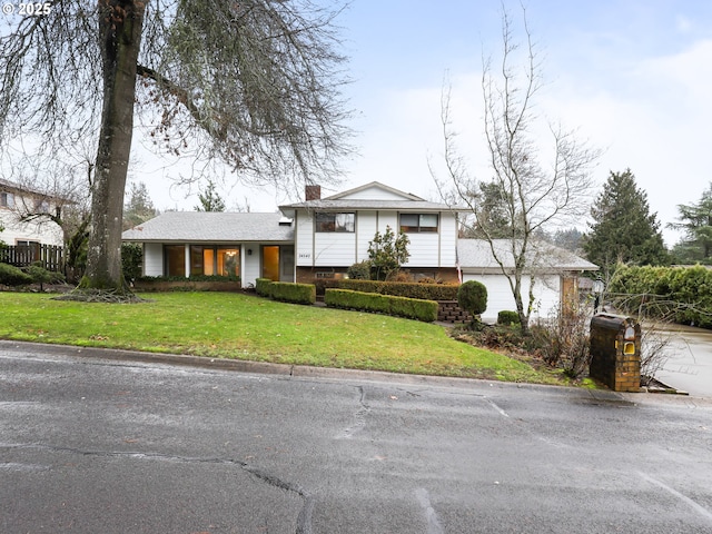 split level home with a front yard and a garage