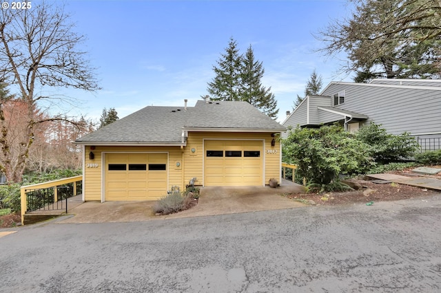 exterior space featuring a garage and roof with shingles