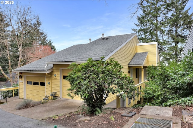 view of front of home with a garage and roof with shingles