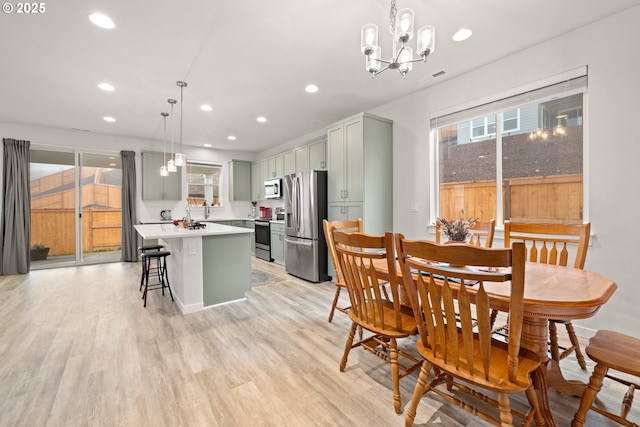 dining space with a notable chandelier and light wood-type flooring