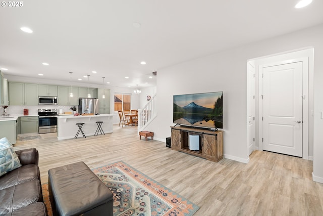 living room featuring light hardwood / wood-style floors and a notable chandelier