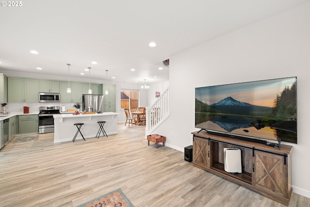 living room with light hardwood / wood-style flooring and a notable chandelier