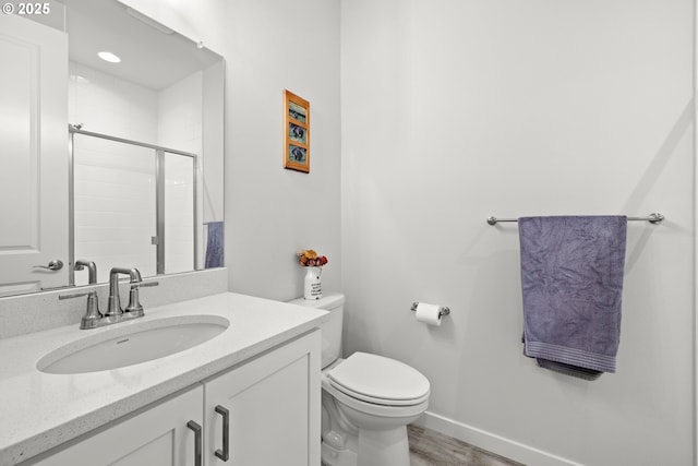 bathroom with a shower with shower door, vanity, toilet, and hardwood / wood-style flooring