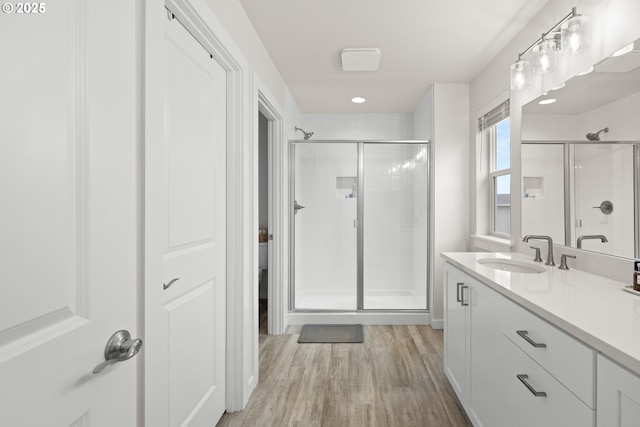 bathroom featuring a shower with shower door, vanity, and hardwood / wood-style floors