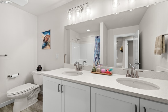 bathroom featuring toilet, hardwood / wood-style flooring, vanity, and curtained shower