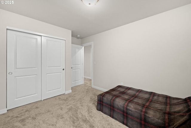 bedroom with light colored carpet and a closet