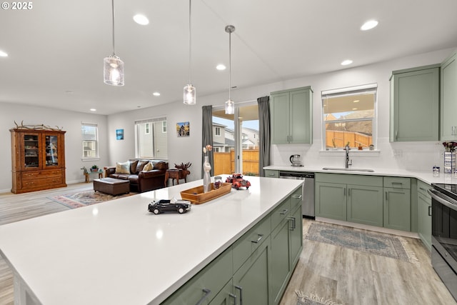 kitchen with sink, stainless steel appliances, and green cabinetry