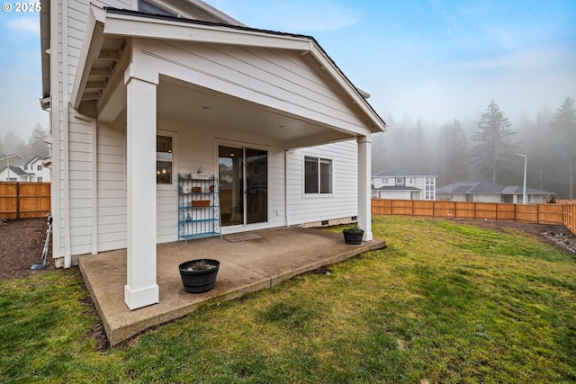 back of house with a yard and a patio