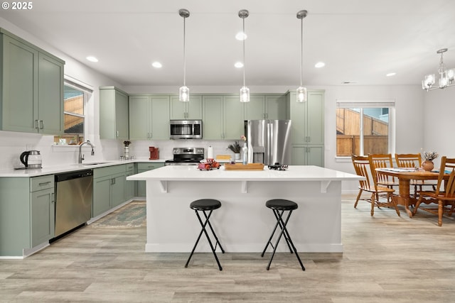 kitchen featuring decorative light fixtures, a kitchen breakfast bar, stainless steel appliances, and a kitchen island