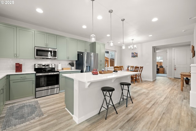 kitchen featuring decorative light fixtures, decorative backsplash, appliances with stainless steel finishes, and green cabinets