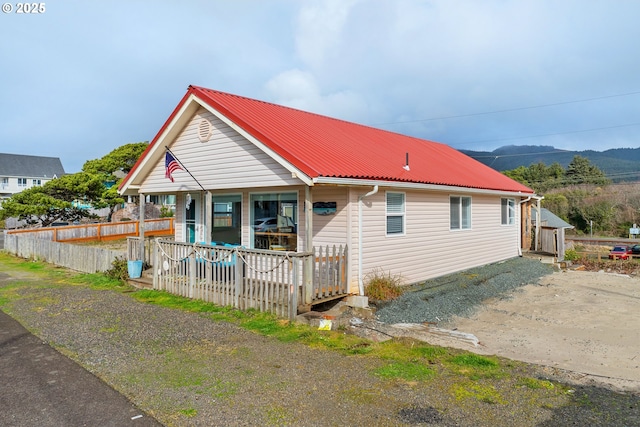 view of front of property featuring a porch, a mountain view, and metal roof