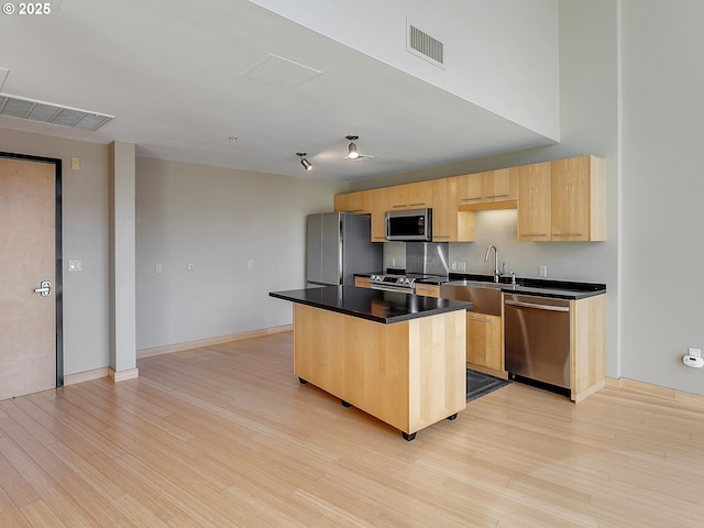 12600 SW Crescent St Unit 219, Beaverton, OR 97005 - kitchen featuring light wood-type flooring, a kitchen island, appliances with stainless steel finishes, and light brown cabinets