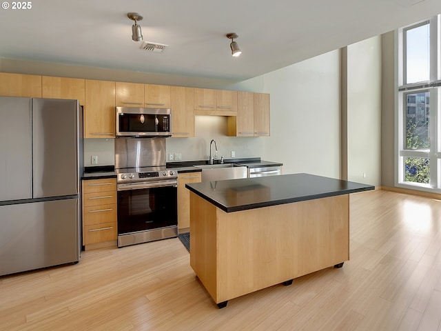 12600 SW Crescent St Unit 219, Beaverton, OR 97005 - kitchen with light brown cabinetry, dark countertops, visible vents, a sink, and appliances with stainless steel finishes