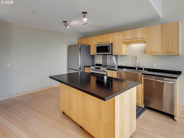 12600 SW Crescent St Unit 219, Beaverton, OR 97005 - kitchen with light wood finished floors, stainless steel appliances, a sink, dark countertops, and visible vents