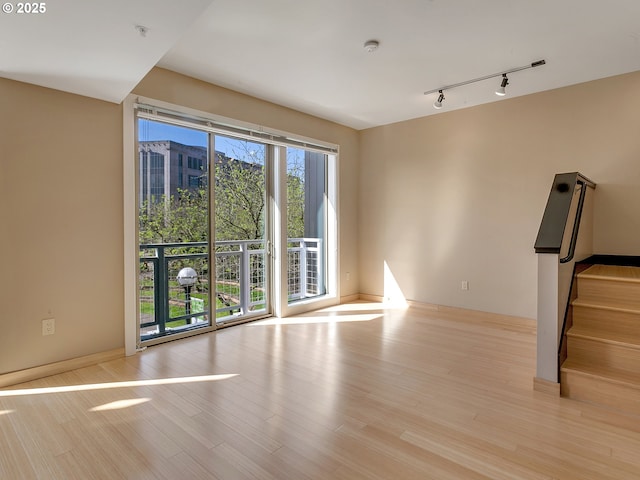 12600 SW Crescent St Unit 219, Beaverton, OR 97005 - unfurnished living room featuring rail lighting, baseboards, and wood finished floors