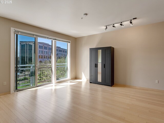 12600 SW Crescent St Unit 219, Beaverton, OR 97005 - spare room featuring rail lighting, baseboards, and light wood-style floors