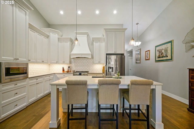 1715 York Butte Ave, Salem, OR 97306 - kitchen featuring a kitchen bar, stainless steel appliances, a kitchen island with sink, decorative backsplash, and custom exhaust hood
