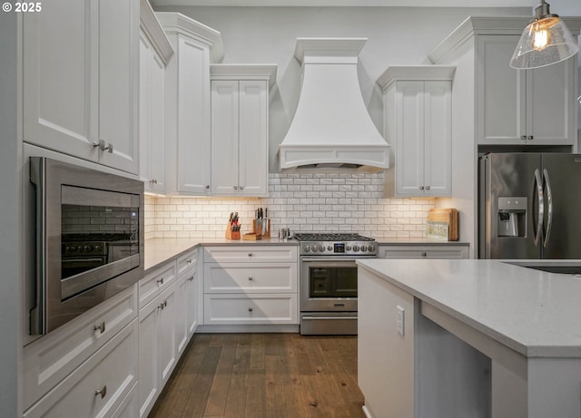 1715 York Butte Ave, Salem, OR 97306 - kitchen with dark wood-style flooring, custom exhaust hood, white cabinetry, tasteful backsplash, and appliances with stainless steel finishes