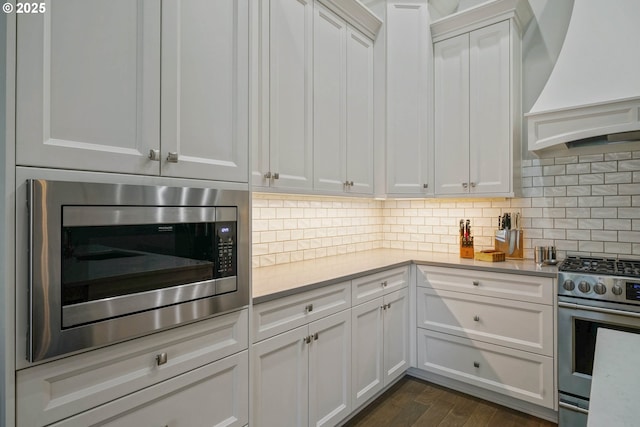 1715 York Butte Ave, Salem, OR 97306 - kitchen featuring white cabinets, light countertops, appliances with stainless steel finishes, decorative backsplash, and custom exhaust hood