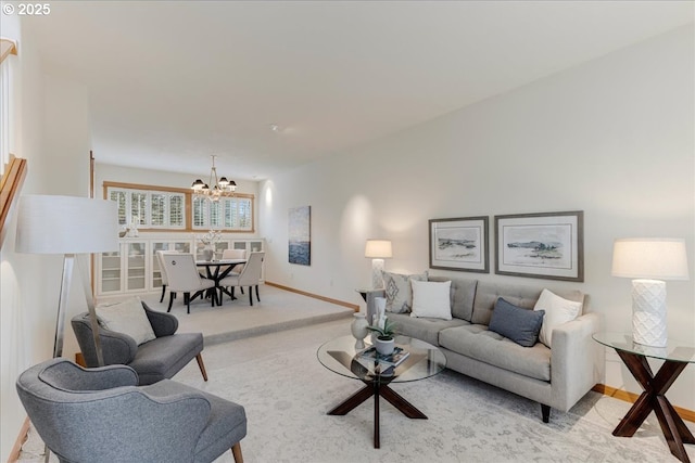 living area with baseboards, light colored carpet, and a chandelier