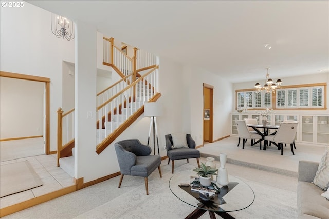 living room with stairs, an inviting chandelier, carpet, and baseboards