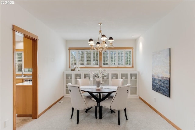 dining area featuring an inviting chandelier, light colored carpet, baseboards, and visible vents