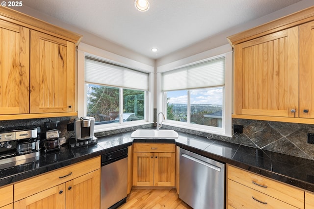 kitchen with decorative backsplash, sink, stainless steel dishwasher, and light wood-type flooring