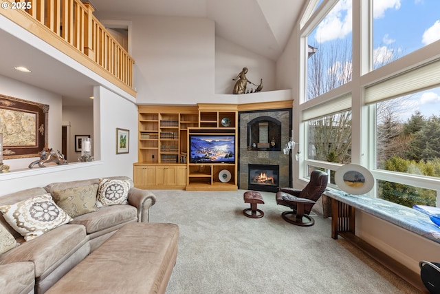 carpeted living room with high vaulted ceiling and a tiled fireplace