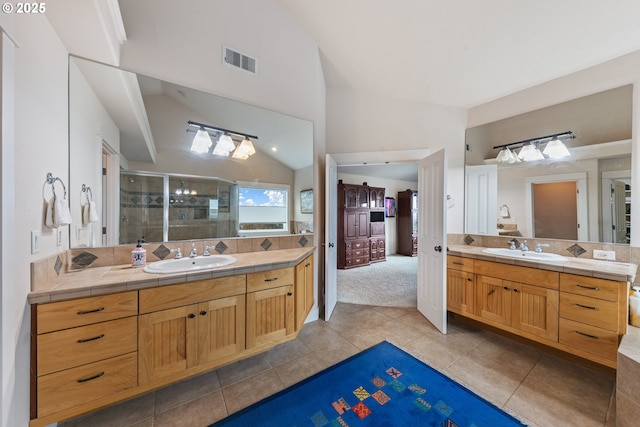 bathroom with tile patterned floors, vanity, vaulted ceiling, and a shower with door