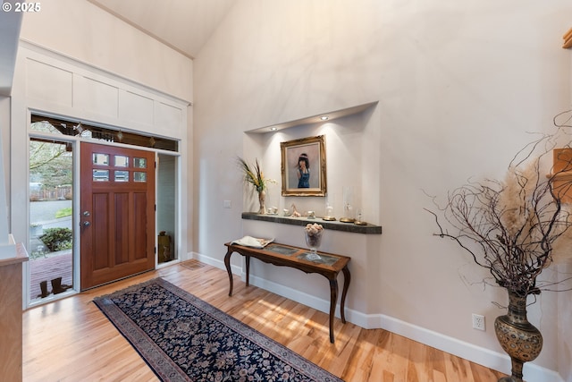 foyer entrance featuring a high ceiling and light hardwood / wood-style floors