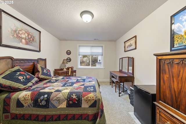 carpeted bedroom with refrigerator and a textured ceiling