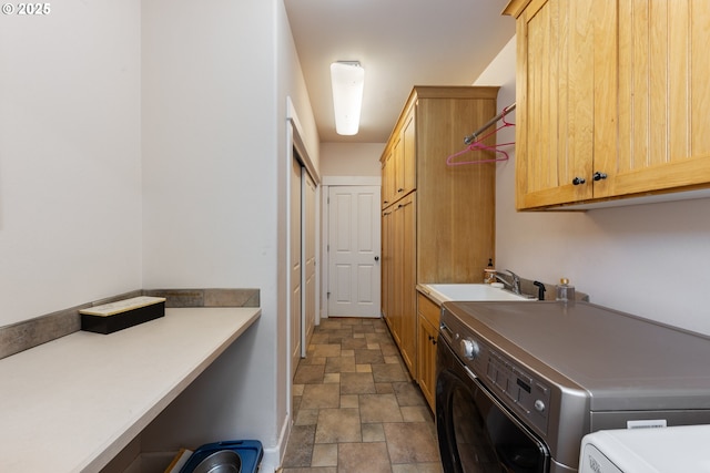 clothes washing area featuring cabinets, independent washer and dryer, and sink