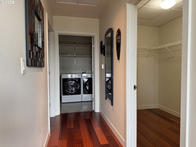 interior space with laundry area, dark wood-type flooring, visible vents, baseboards, and washer and clothes dryer
