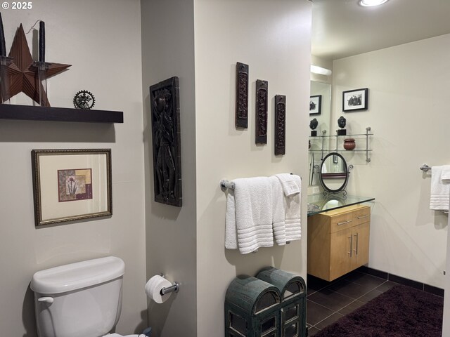 half bath with tile patterned flooring, vanity, and toilet