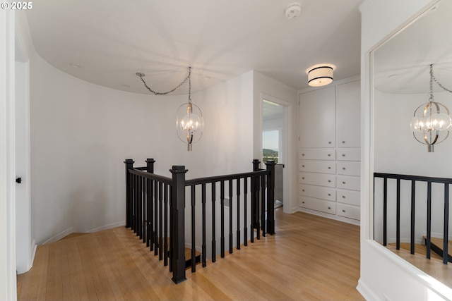 hallway featuring light hardwood / wood-style floors and a chandelier