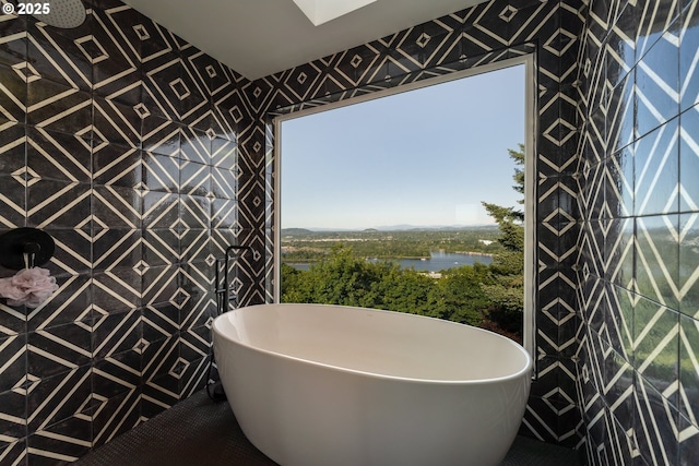 bathroom featuring a tub, tile patterned flooring, and a water view