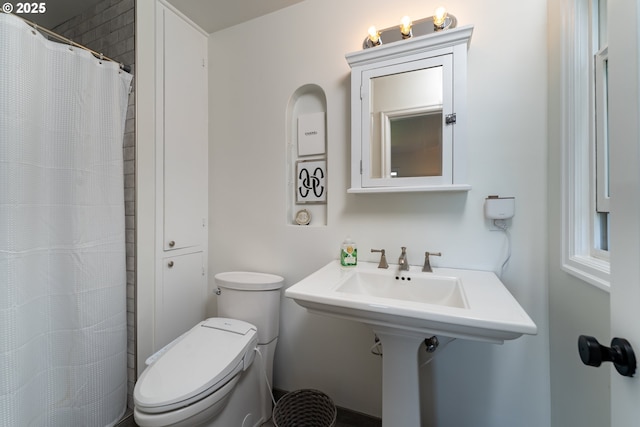 bathroom featuring toilet and walk in shower